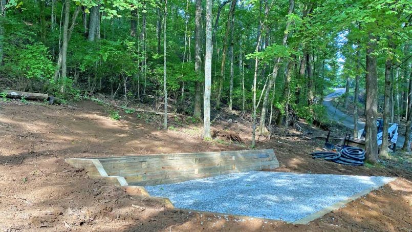 Side view stone base foundation with L-shaped retaining wall