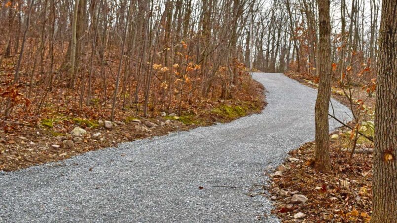 Gravel driveway leads up to stone base pads