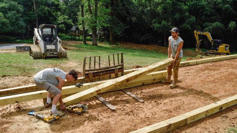 Two workers setting timbers at bocce ball court